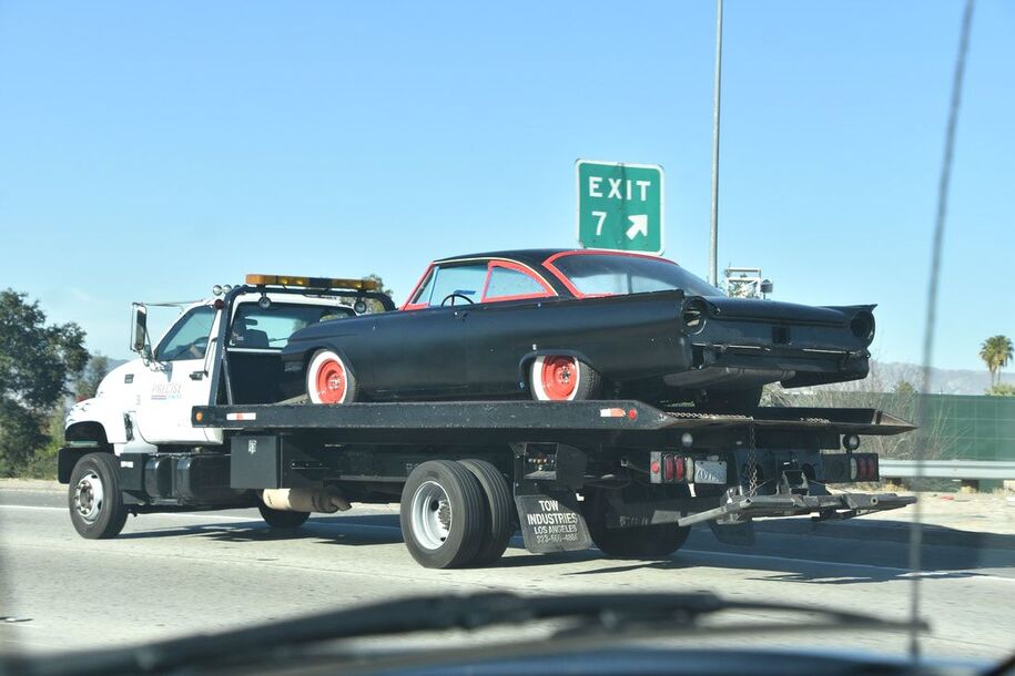 Retro car being towed on flat bed Morrisville Towing tow truck